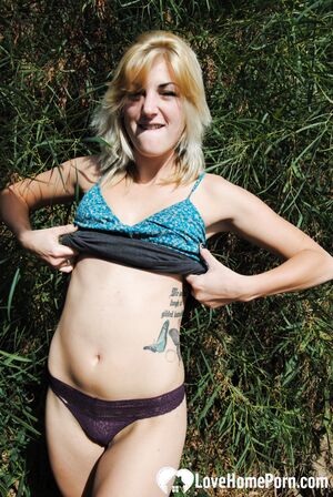 Blonde with tattoos does a striptease outside