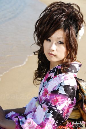 Asian Chiaki in kimono is romantic and beautiful at the ocean's shore.