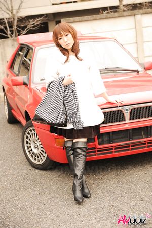 Asian Yuko Morita in white coat and long boots poses in her car.
