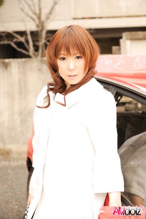 Asian Yuko Morita in white coat and long boots poses in her car.