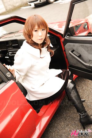 Asian Yuko Morita in white coat and long boots poses in her car.