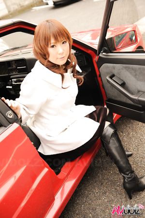 Asian Yuko Morita in white coat and long boots poses in her car.
