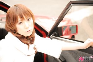 Asian Yuko Morita in white coat and long boots poses in her car.