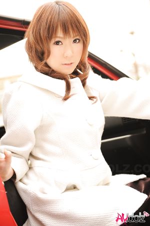 Asian Yuko Morita in white coat and long boots poses in her car.