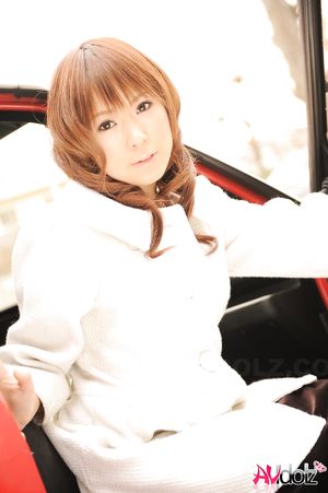 Asian Yuko Morita in white coat and long boots poses in her car.