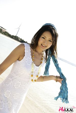 Risa in a white long dress shows legs while taking a bath in the sea.