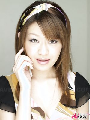 Nagisa Sasaki spreads legs while posing in a colorful dress and heels.