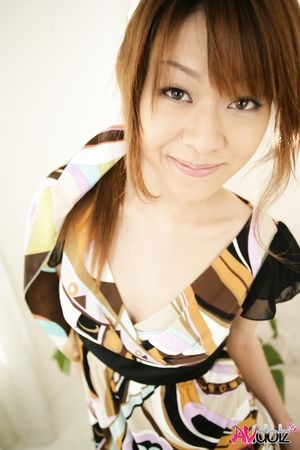 Nagisa Sasaki spreads legs while posing in a colorful dress and heels.