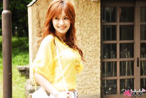 Mecumi in yellow blouse and shorts has a pleasant walk in the city.