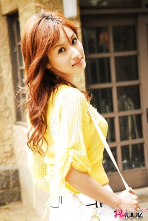 Mecumi in yellow blouse and shorts has a pleasant walk in the city.