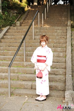 Asian Ichika in a beautiful kimono makes some soap bubbles outdoor.