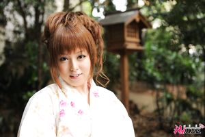 Asian Ichika in a beautiful kimono makes some soap bubbles outdoor.