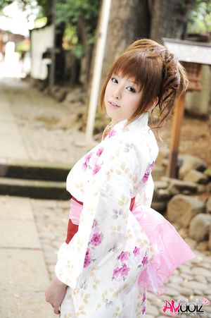 Asian Ichika in a beautiful kimono makes some soap bubbles outdoor.