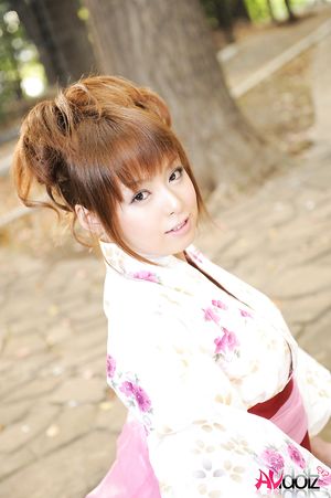 Asian Ichika in a beautiful kimono makes some soap bubbles outdoor.