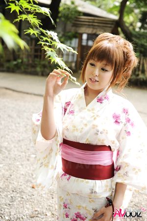 Asian Ichika in a beautiful kimono makes some soap bubbles outdoor.
