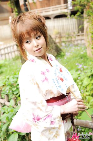 Asian Ichika in a beautiful kimono makes some soap bubbles outdoor.