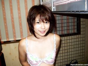 Horny and busty Asian chick poses topless and naked for the camera