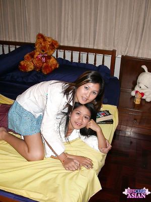 Two naked horny asian lesbians posing and give tender kisses