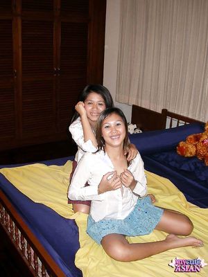 Two naked horny asian lesbians posing and give tender kisses