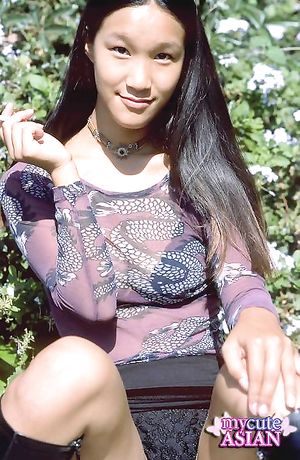Long haired asian babe putting a gold dildo in her wet pussy