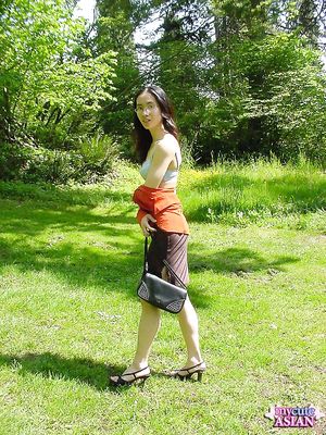 Long haired asian beauty shows her round tits in forest here