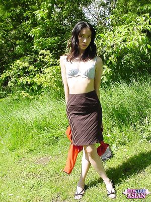 Long haired asian beauty shows her round tits in forest here