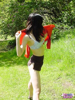 Long haired asian beauty shows her round tits in forest here