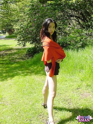 Long haired asian beauty shows her round tits in forest here