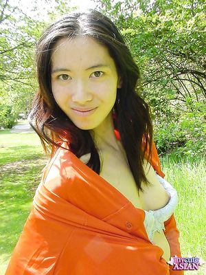Long haired asian beauty shows her round tits in forest here