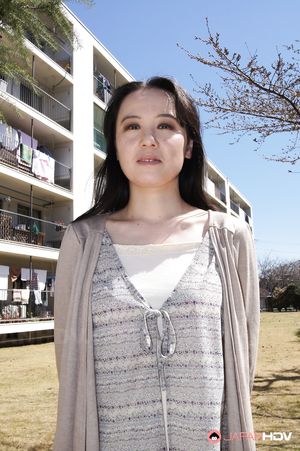 Junko Nishimura is an Asian lady presenting her new outfit outdoors.