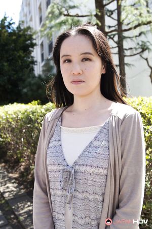Junko Nishimura is an Asian lady presenting her new outfit outdoors.