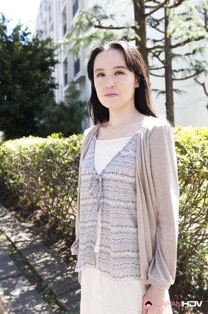 Junko Nishimura is an Asian lady presenting her new outfit outdoors.