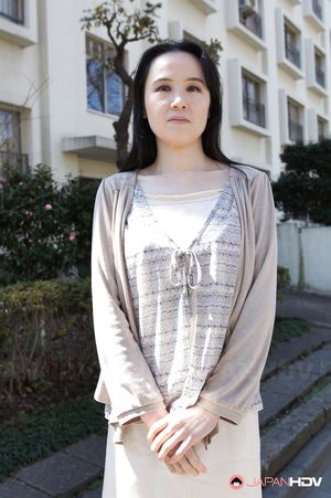 Junko Nishimura is an Asian lady presenting her new outfit outdoors.