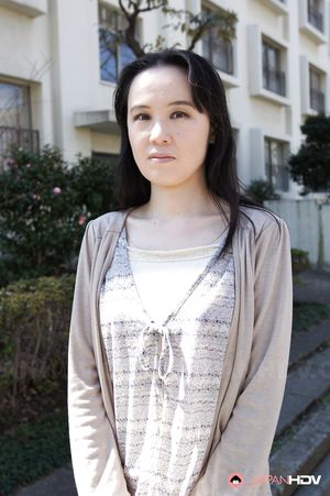 Junko Nishimura is an Asian lady presenting her new outfit outdoors.