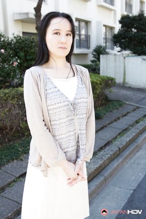 Junko Nishimura is an Asian lady presenting her new outfit outdoors.