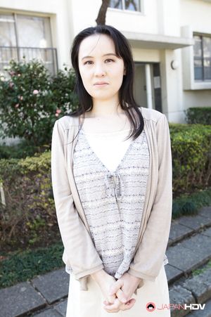 Junko Nishimura is an Asian lady presenting her new outfit outdoors.
