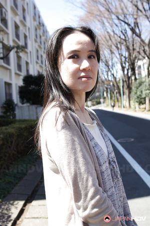 Junko Nishimura is an Asian lady presenting her new outfit outdoors.