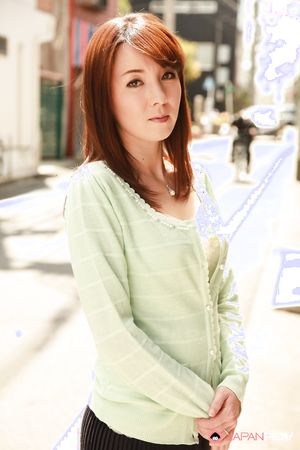 Chika Sasaki in green sweater and short skirt poses on the streets.