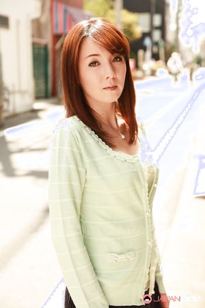 Chika Sasaki in green sweater and short skirt poses on the streets.