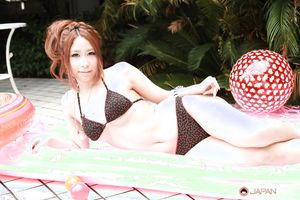 Adorable young Asian model showing her sexy curves by the pool