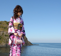 Asian Chiaki in kimono is romantic and beautiful at the ocean's shore.