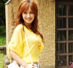 Mecumi in yellow blouse and shorts has a pleasant walk in the city.